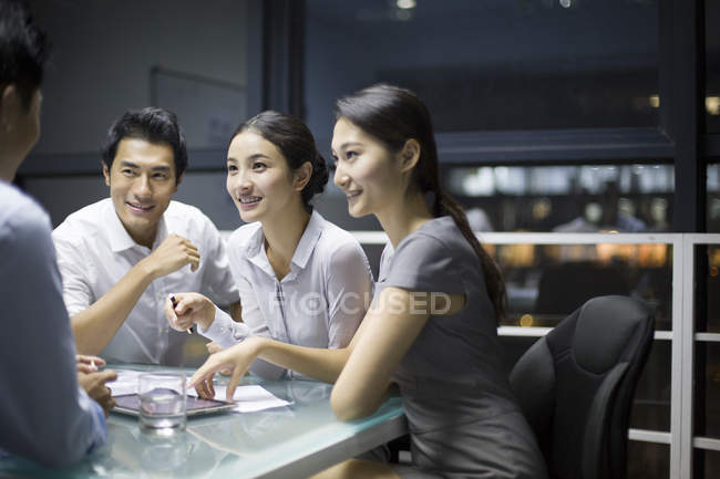 Equipo empresarial chino hablando en reunión - foto de stock