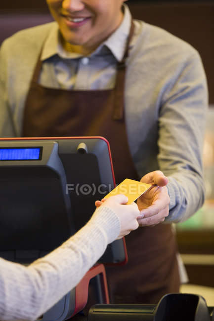 Cliente feminino que paga com cartão de crédito no café — Fotografia de Stock