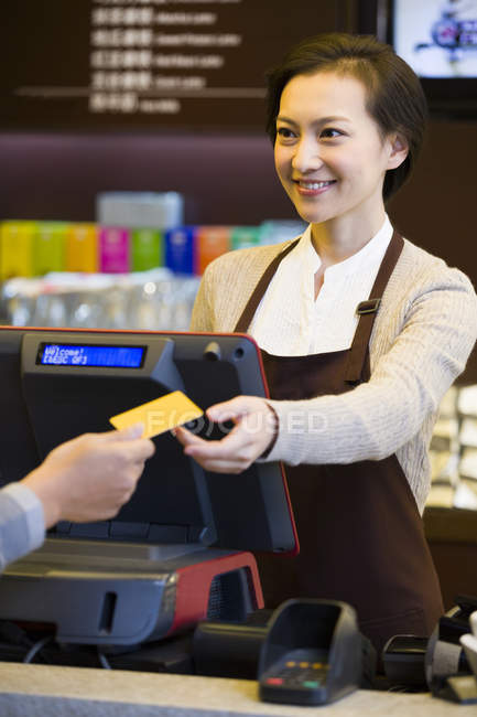 Cliente pagando con tarjeta de crédito en cafetería - foto de stock