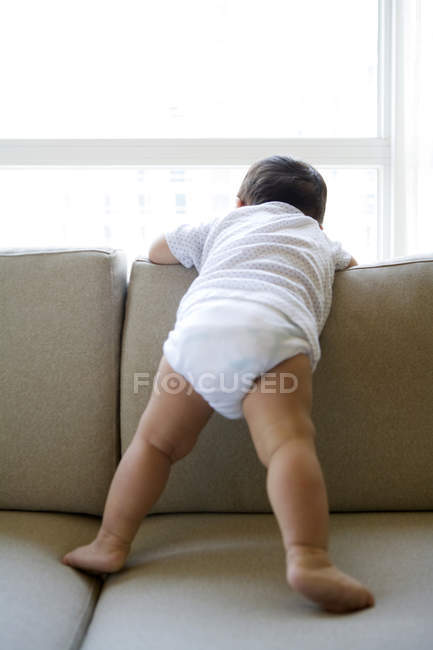 Bebé niño apoyado en sofá espalda - foto de stock