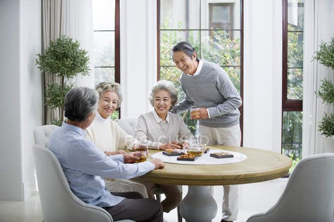 Senior Chinese friends relaxing and talking while tea party — Stock Photo