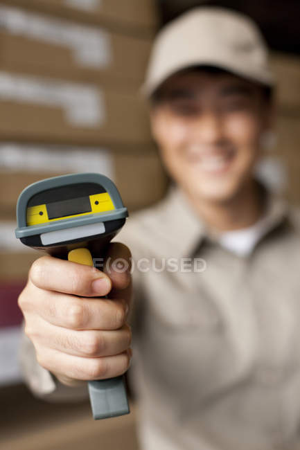 Male Chinese warehouse worker holding scanner — Stock Photo