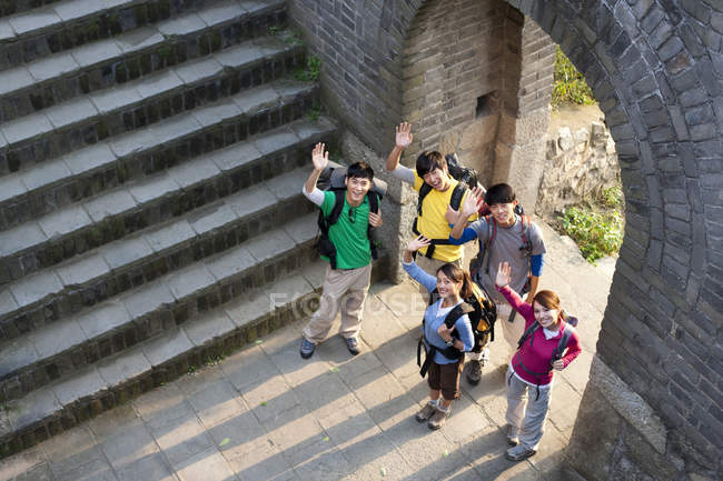 Gruppo di backpackers cinesi che salutano sulla Grande Muraglia — Foto stock