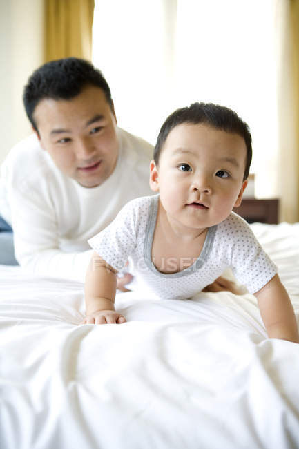 Chinese man with crawling baby boy — Stock Photo