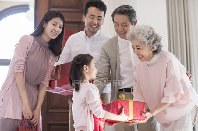 Petite-fille donnant des cadeaux de grands-parents pendant la nouvelle année chinoise — Photo de stock