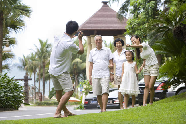 Chinese man filming multi-generation family on vacation — Stock Photo