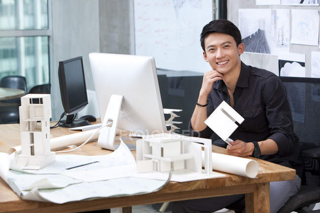 Китайский архитектор улыбается в офисе — стоковое фото