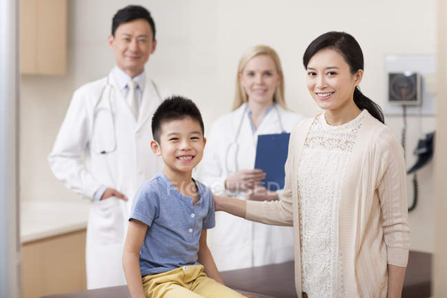Chinese boy and mother with pediatricians in hospital — Stock Photo