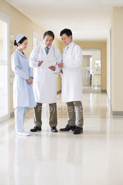 Squadra medica cinese in discussione nel corridoio ospedaliero — Foto stock