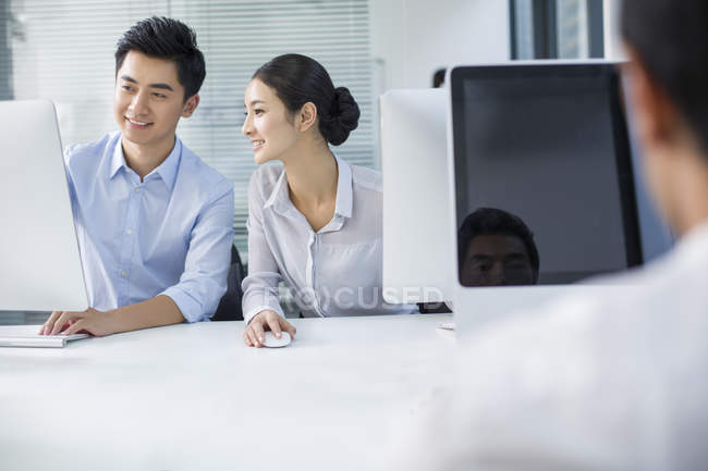 Chinese businesswoman and businessmen working in office — Stock Photo