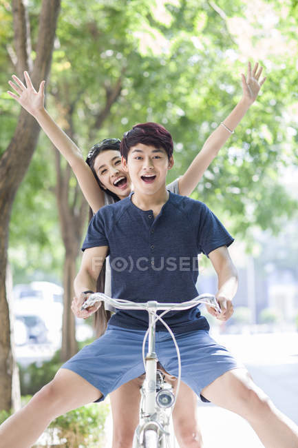 Chinese couple riding bicycle together — Stock Photo