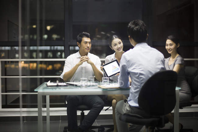 Chinesische Geschäftsleute sitzen bei Treffen mit digitalem Tablet — Stockfoto