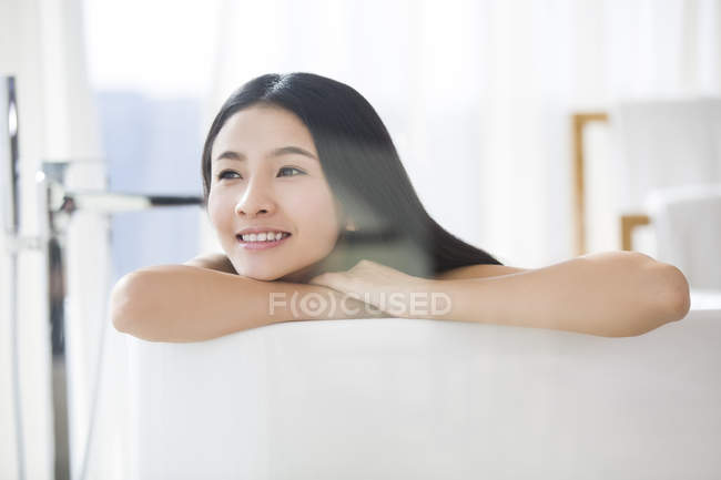 Chinesin liegt und denkt in Badewanne — Stockfoto