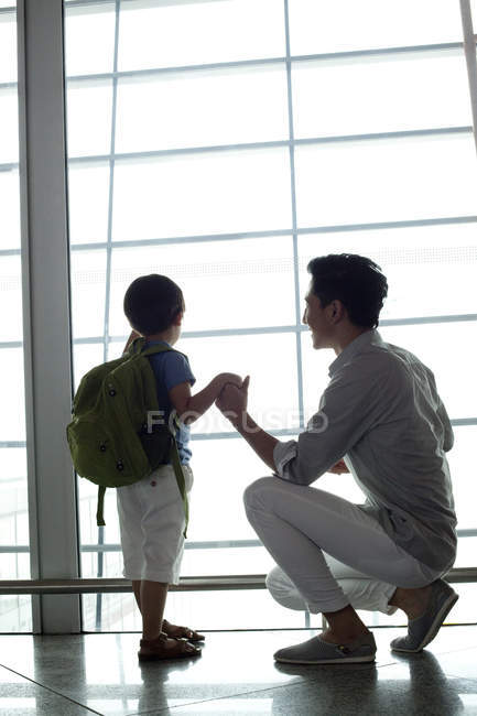 Chinese father and son looking at view at airport — Stock Photo