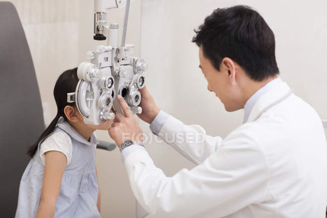 Chino médico examinar chica ojos - foto de stock