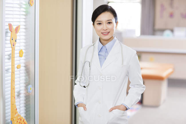 Pediatra chino mirando en cámara en el hospital - foto de stock