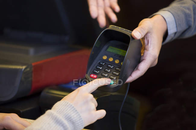 Close-up do cliente digitando senha do cartão de crédito — Fotografia de Stock