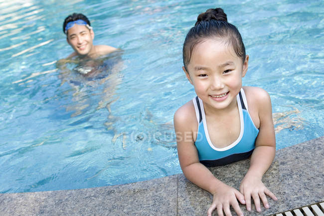 Chinese father and daughter swimming in pool — Stock Photo