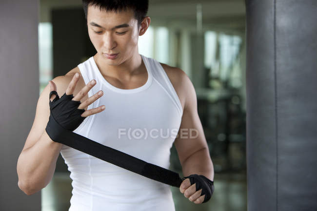 Chinese man putting on hand wrap — Stock Photo