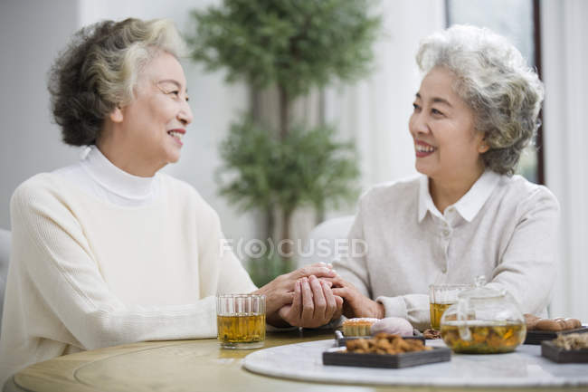 Senior Chinese women talking and drinking tea — Stock Photo