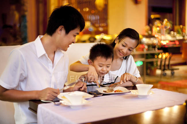 Genitori cinesi con figlio che pranzano nel ristorante — Foto stock