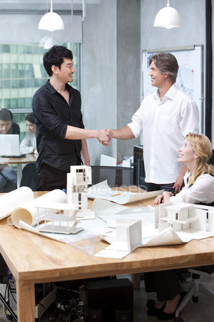 Архитекторы-мужчины пожимают друг другу руки в офисе — стоковое фото
