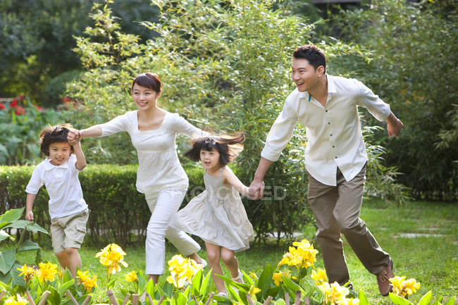 China familia corriendo y divertirse en el jardín - foto de stock