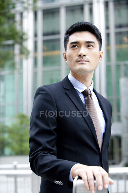 Selbstbewusster chinesischer Geschäftsmann mit Blick auf die Straße — Stockfoto