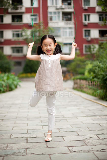 Chinese girl jumping rope on street — Stock Photo