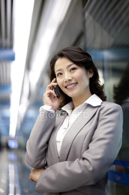 Mulher de negócios chinesa falando no telefone dentro de casa — Fotografia de Stock