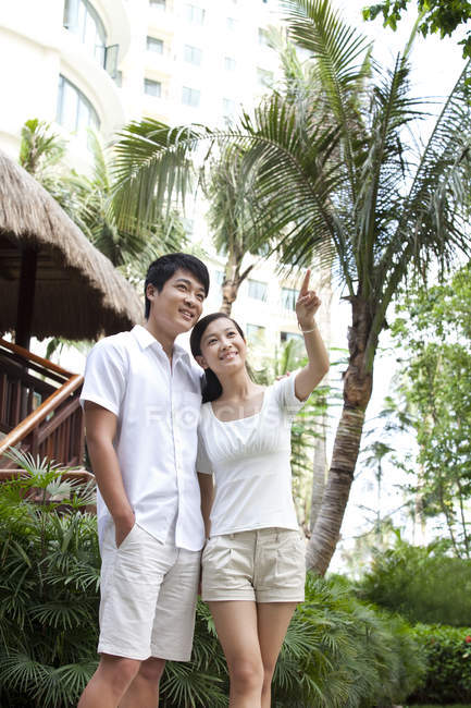 Chinese couple pointing at view on vacation — Stock Photo