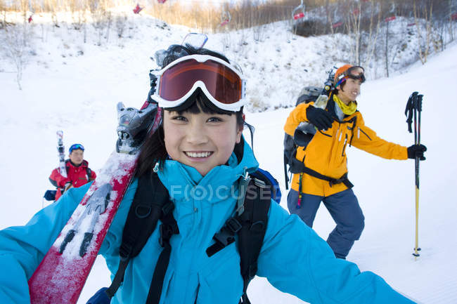Mulher chinesa caminhando com homens na estância de esqui — Fotografia de Stock