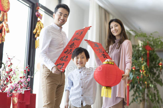 Веселая семья с декоративными баннерами и фонариком на китайский Новый год — стоковое фото
