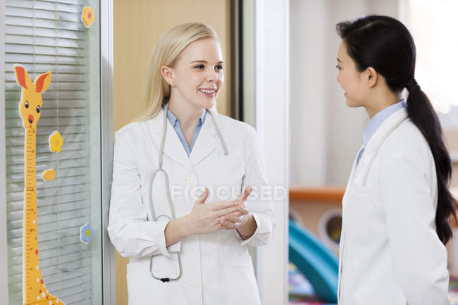Médicos hablando en un hospital infantil - foto de stock