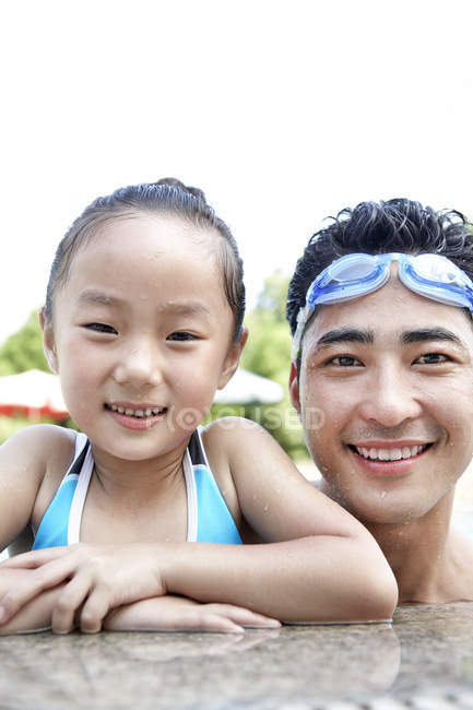 Chinese father and daughter posing at poolside — Stock Photo