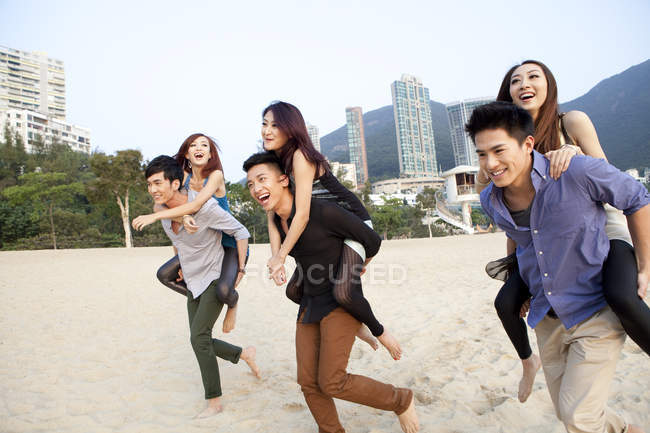 Chinois jouant au piggyback sur la plage à Repulse Bay, Hong Kong — Photo de stock