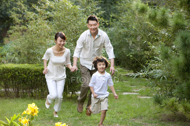 Chinesische Familie läuft und hat Spaß im Garten — Stockfoto