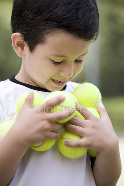 Ritratto di piccolo ragazzo cinese che tiene le palle da tennis — Foto stock