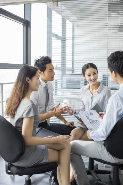 Empresarios chinos discutiendo trabajo en reunión - foto de stock