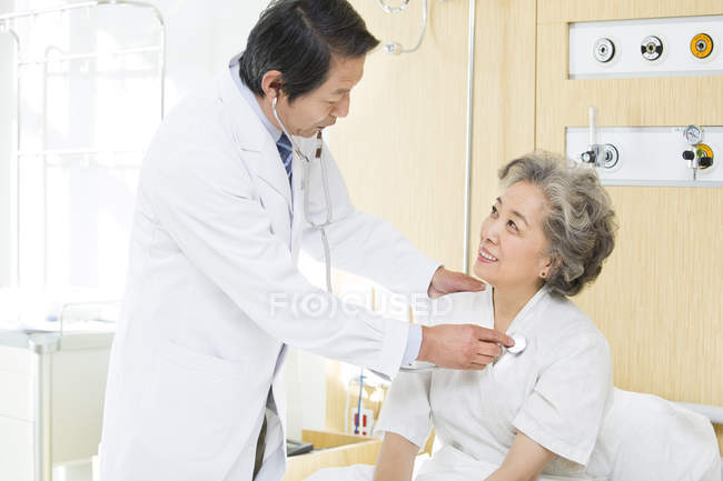 Китайский врач использует стетоскоп на пациенте в больнице — стоковое фото