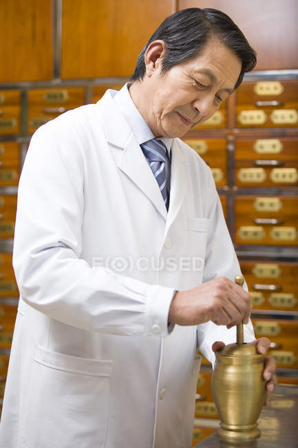 Senior medico cinese macinazione erbe medicinali — Foto stock