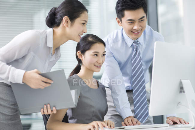 Empresarios chinos usando computadora en la oficina - foto de stock