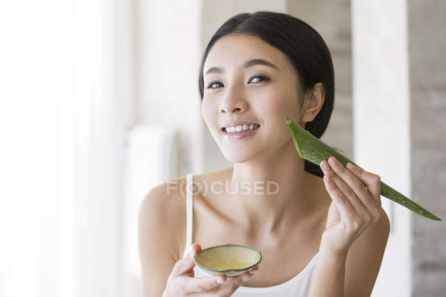 Mulher chinesa aplicando hidratante aloe vera natural — Fotografia de Stock