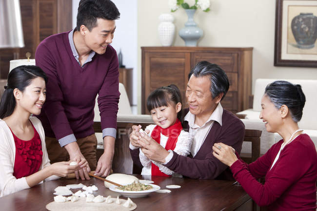 Allegro famiglia multi-generazione rendendo gnocchi cinesi — Foto stock