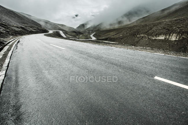 Estrada em montanhas com curva de grampo de cabelo no Tibete, China — Fotografia de Stock