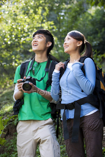 Amigos chinos con cámara digital en caminata en el bosque - foto de stock