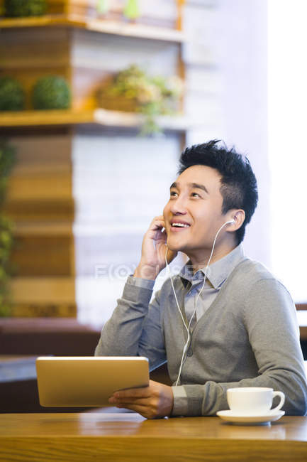 Китайська людина користуються музики в цифровий планшетний в кафе — стокове фото