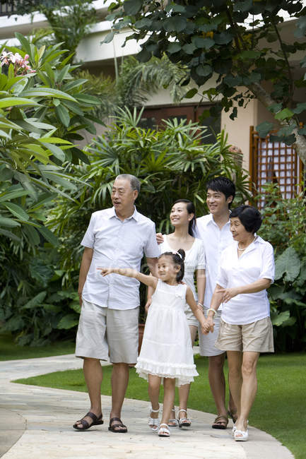 Chinese family with girl standing and pointing at tourist resort — Stock Photo