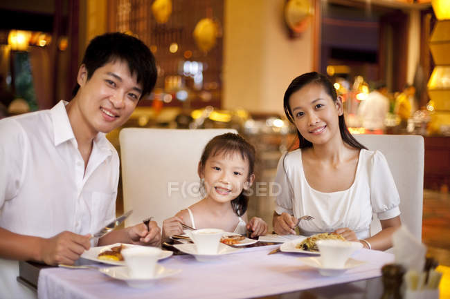 Pais chineses com filha jantando no restaurante — Fotografia de Stock