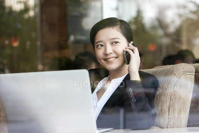 Китайская деловая женщина разговаривает по телефону в кафе — стоковое фото